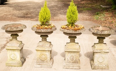 Lot 786 - A set of four composition stone urns, each on...