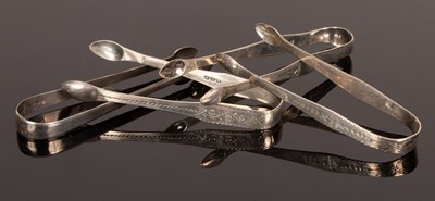 Lot 95 - Four pairs of George III silver sugar tongs,...
