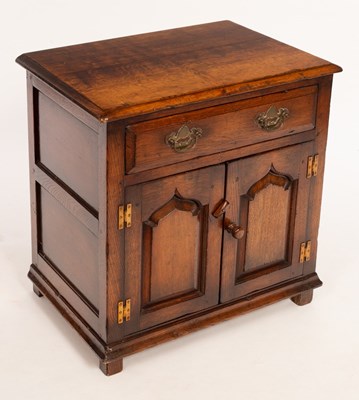 Lot 556 - An oak cupboard fitted a drawer, enclosed by a...