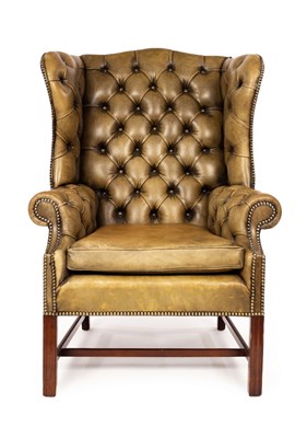 Lot 566 - A wingback armchair upholstered in green...