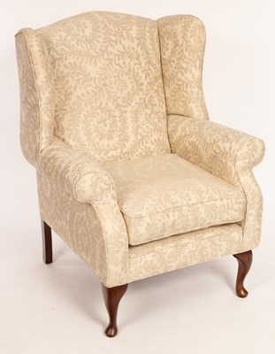 Lot 581 - A wingback armchair fitted a loose seat cover,...