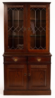 Lot 597 - An oak display case with cupboards and drawers...