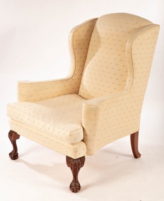 Lot 680 - An upholstered wing back chair with ball and...