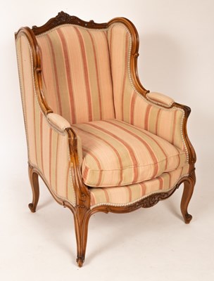 Lot 717 - A French walnut framed wing back armchair, the...