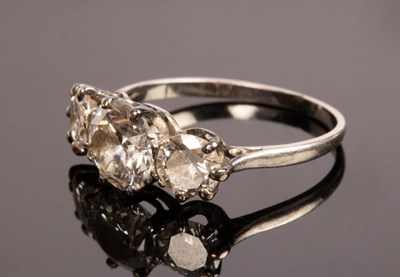 Lot 8 - A diamond three-stone ring, the claw set...