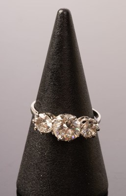 Lot 8 - A diamond three-stone ring, the claw set...