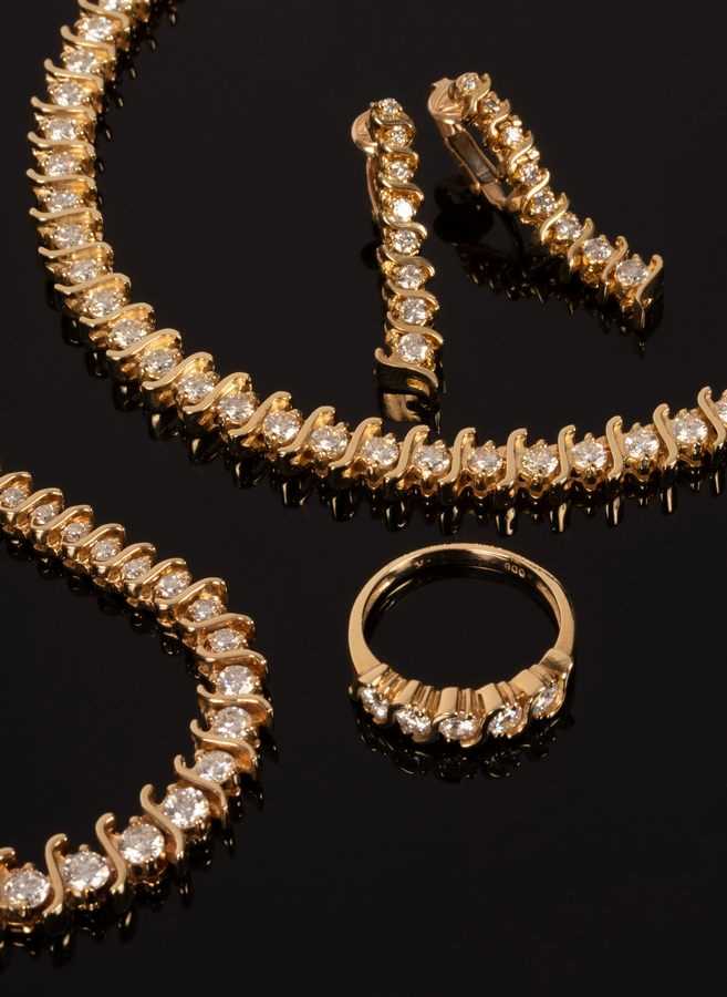 Lot 9 - A diamond set tennis bracelet in a 14k yellow...