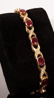 Lot 10 - A ruby and diamond bracelet, the twelve oval...