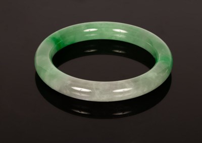 Lot 312 - A green jadeite bangle, 20th Century, 7.5cm...