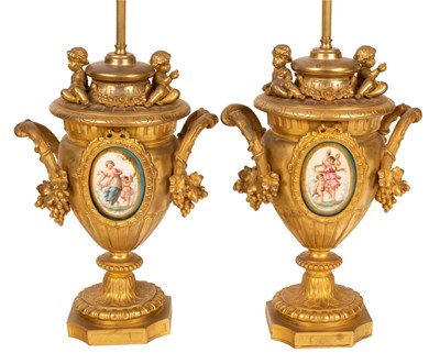 Lot 899 - A pair of gilt metal table lamps of urn form,...