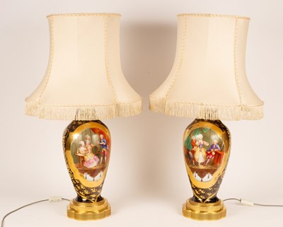 Lot 900 - A pair of porcelain table lamps decorated...