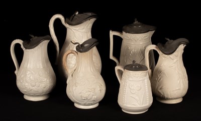 Lot 189 - Six saltware jugs, floral decoration, pewter...