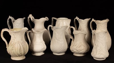 Lot 196 - Ten saltware jugs, most with floral decoration,...