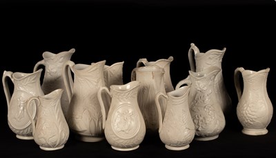 Lot 200 - Twelve saltware jugs, floral decoration...