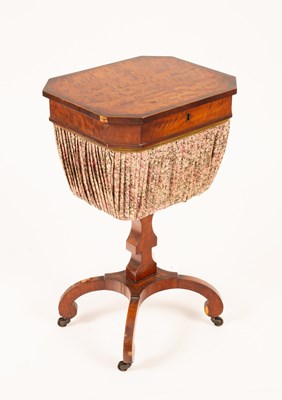 Lot 804 - A Regency satinwood work table, the hinged lid...