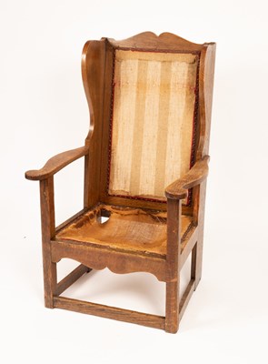 Lot 813 - An Arts & Crafts oak wingback armchair, carved...