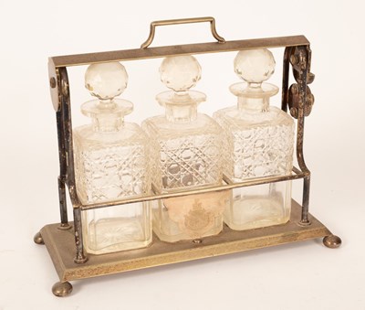 Lot 184 - A plated Tantalus fitted three cut glass...