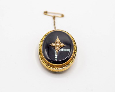 Lot 206 - A Victorian oval onyx mourning brooch, centred...