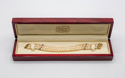 Lot 217 - A triple-row cultured pearl bracelet, with two...