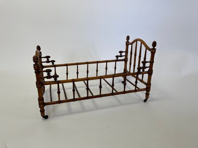 Lot 534 - A doll's bed in faux bamboo, 64cm long