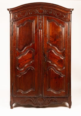 Lot 704 - A Continental walnut armoire enclosed by panel...