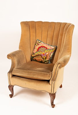 Lot 540 - A beige upholstered wingback armchair on...