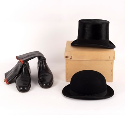 Lot 511 - A black silk top hat by Henry Heath Ltd.,...