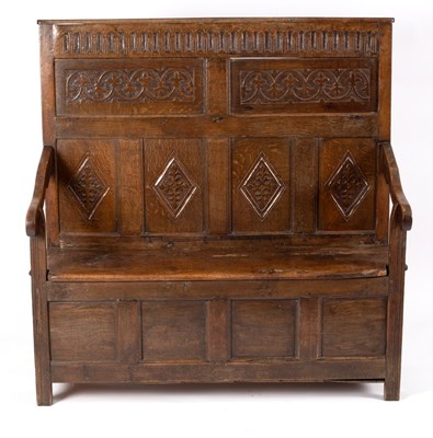 Lot 561 - A Jacobean oak settle, the panel back with...