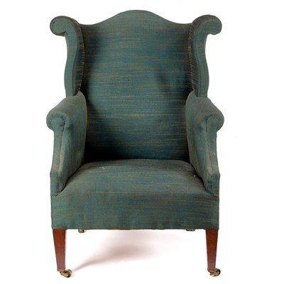 Lot 622 - An upholstered wing back armchair with shaped...