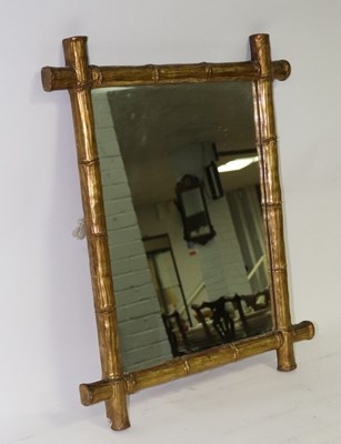 Lot 637 - A wall mirror with a gilded simulated bamboo...