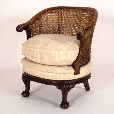 Lot 692 - A tub armchair with a cane back above a cream...