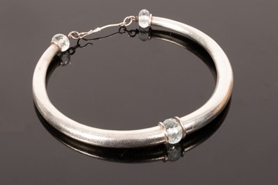 Lot 13 - A white metal torc necklace, faceted pale blue...