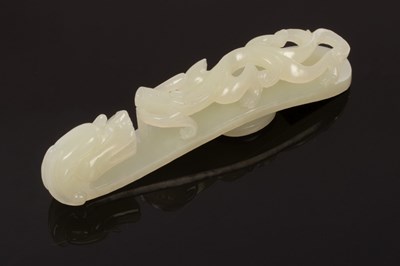 Lot 624 - A Chinese white jade carved belt hook, Qing,...