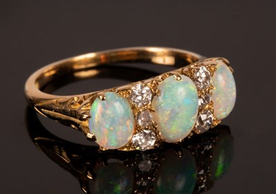 Lot 187 - An opal three-stone ring, the oval opals...