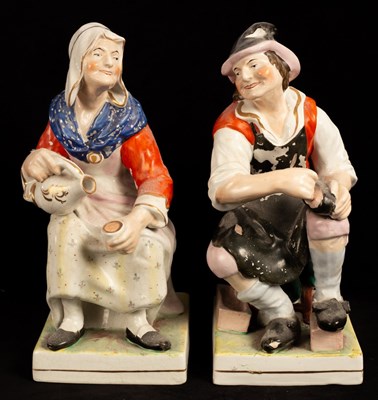 Lot 460 - A pair of earthenware figures of a seated...