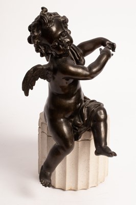 Lot 556 - A bronze figure of a seated cherub, mounted on...