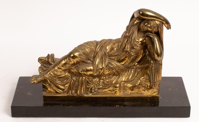 Lot 561 - A gilt metal figure of a reclining female...