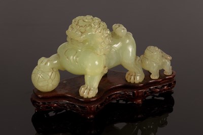 Lot 959 - A celadon jade caving of a foo dog and young,...