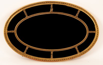 Lot 1137 - A Regency style oval gilt wood sectional wall...