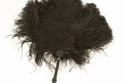 Lot 293 - A black ostrich feather fan on a black carved handle