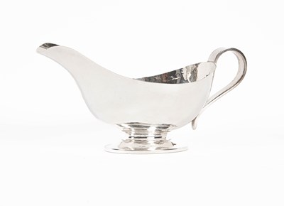 Lot 377 - An Arts & Crafts hammered silver sauce boat