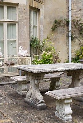 Lot 18 - A Haddonstone garden table on dolphin supports and two benches
