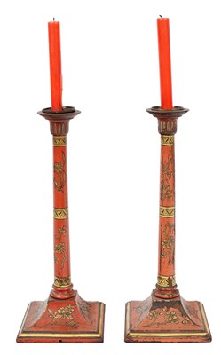 Lot 28 - A pair of red lacquer candlesticks