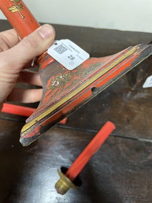 Lot 28 - A pair of red lacquer candlesticks