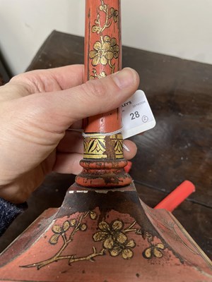 Lot 28 - A pair of red lacquer candlesticks