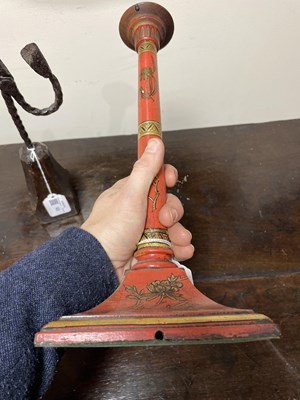 Lot 28 - A pair of red lacquer candlesticks