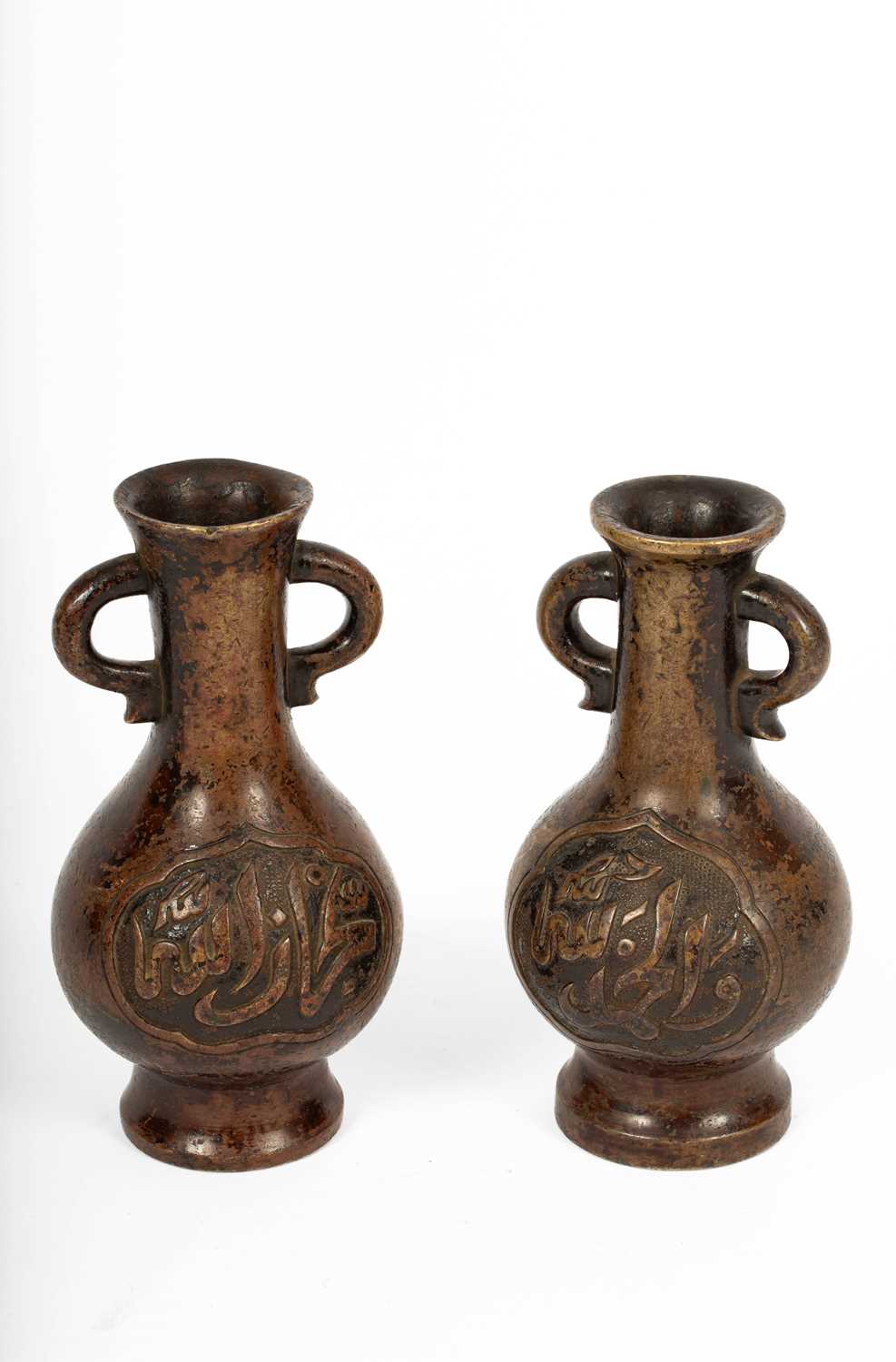 Lot 589 - A near pair of Arabic inscribed bronze baluster vases