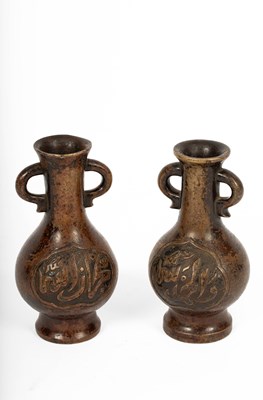 Lot 589 - A near pair of Arabic inscribed bronze baluster vases