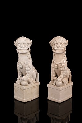 Lot 555 - A pair of Chinese blanc-de-chine figures of dogs of Fo