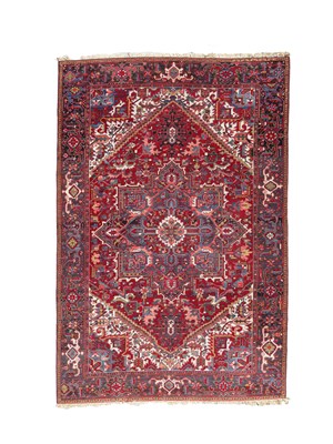 Lot 287 - A machine made carpet of Heriz design